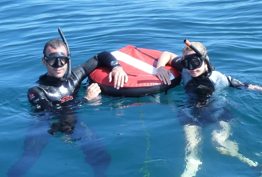 Freediver at the surface beside a training buoy