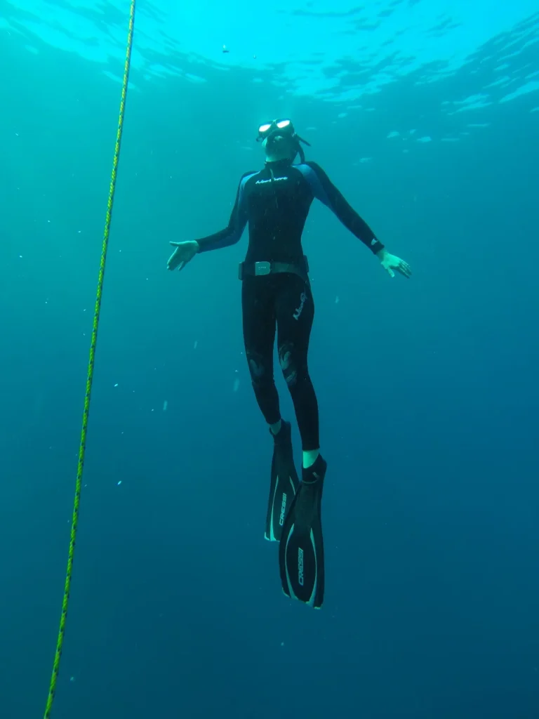 Freediver ascending beside a vertical training line