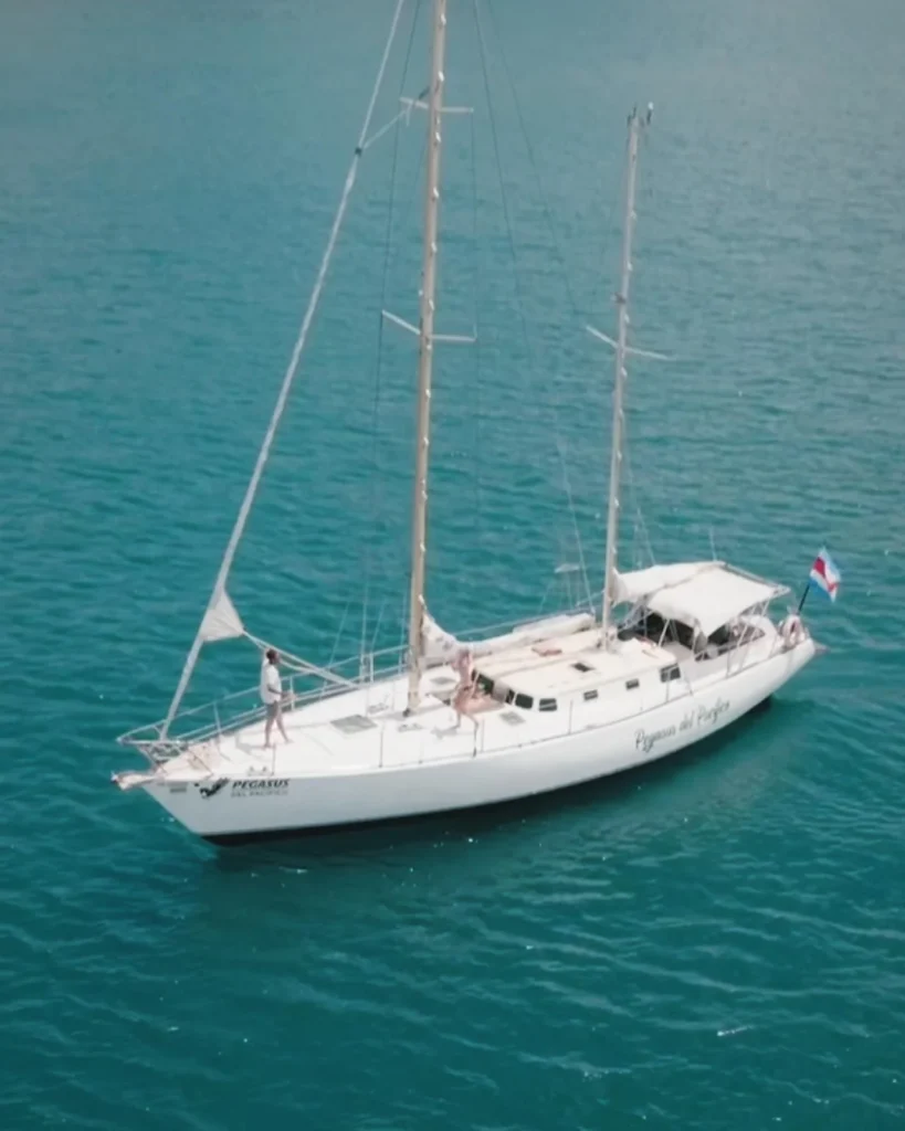 Aerial view of Pegasus with sails lowered in blue water off Playa Flamingo